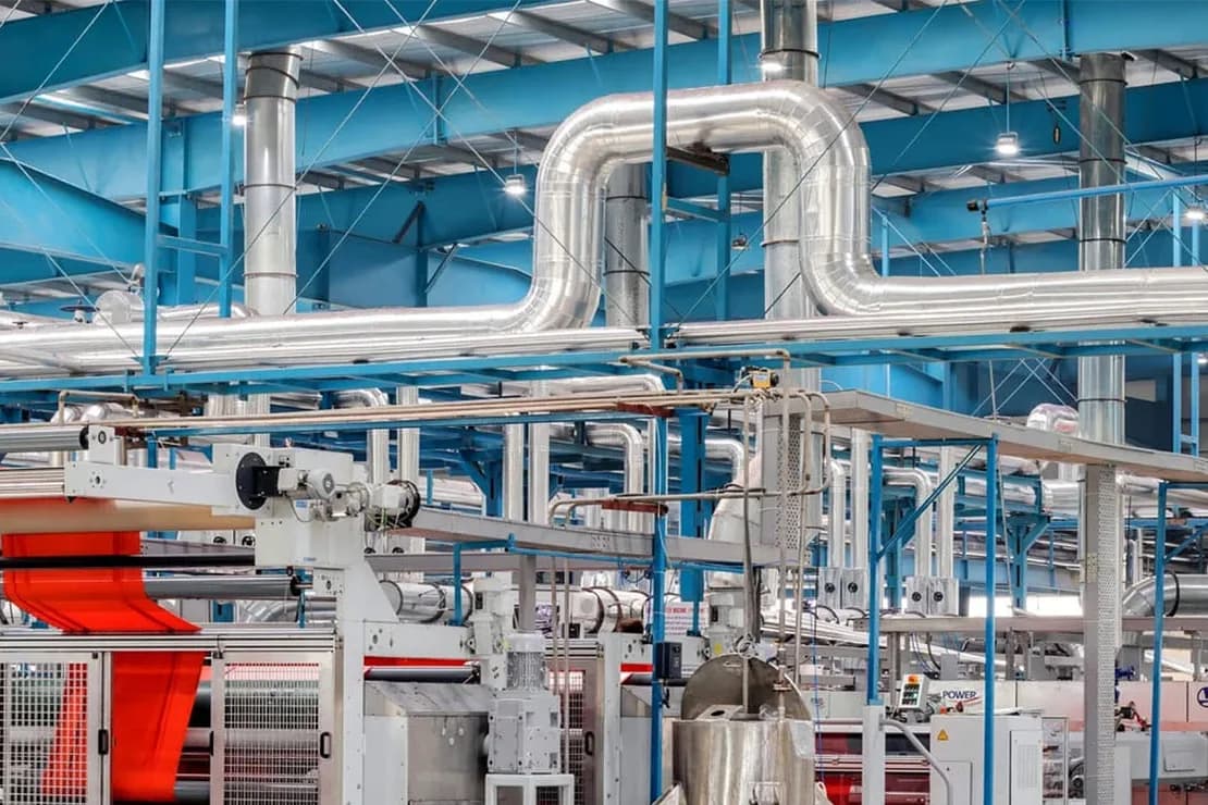 Planta textil con cañerías aisladas sobre la línea de producción